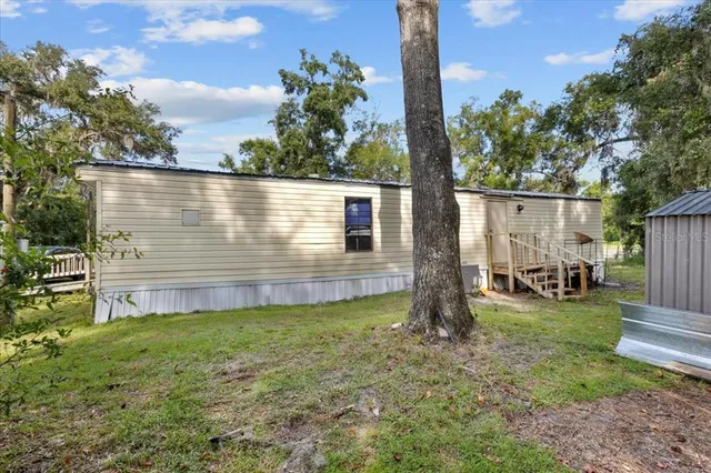 a view of a house with backyard and sitting area