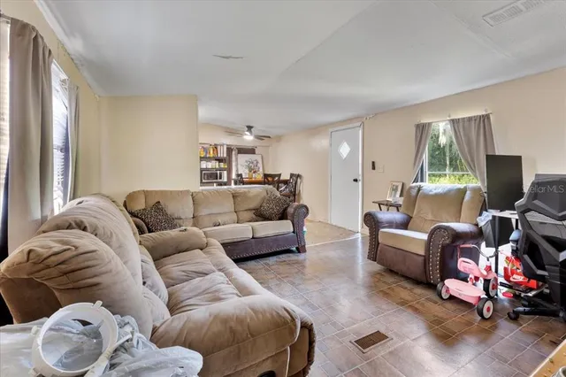 a living room with furniture window and a flat screen tv