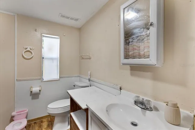 a bathroom with a sink toilet and mirror