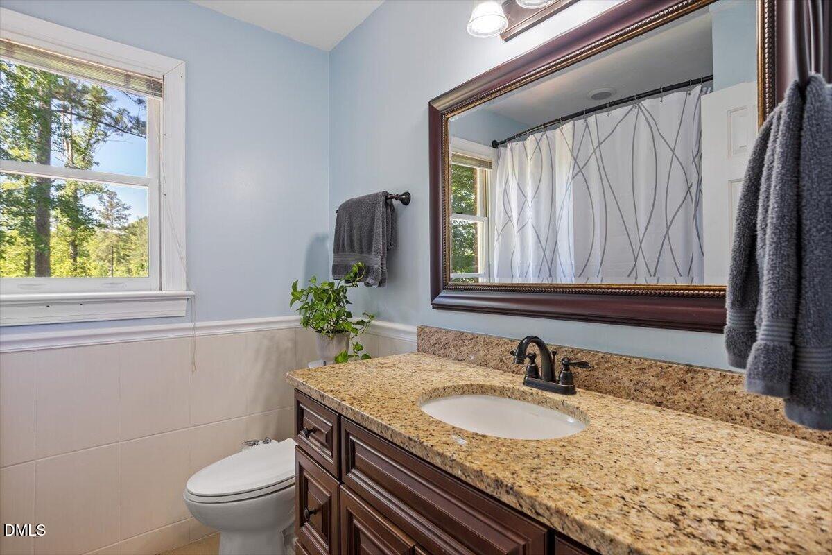 1468 Frazier Road Spring Hope, NC 27882 - Photo 28 of 71 a bathroom with a granite countertop sink and a toilet
