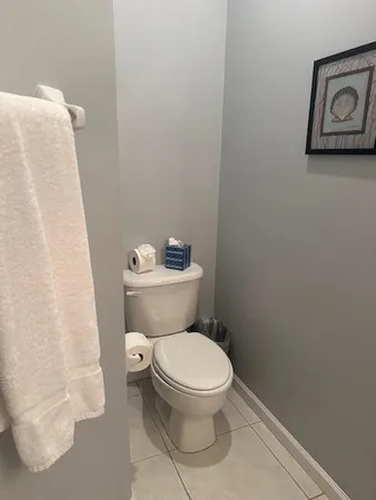 a white toilet sitting next to a white wall
