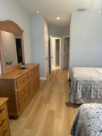 a bedroom with a bed and a mirror on dresser