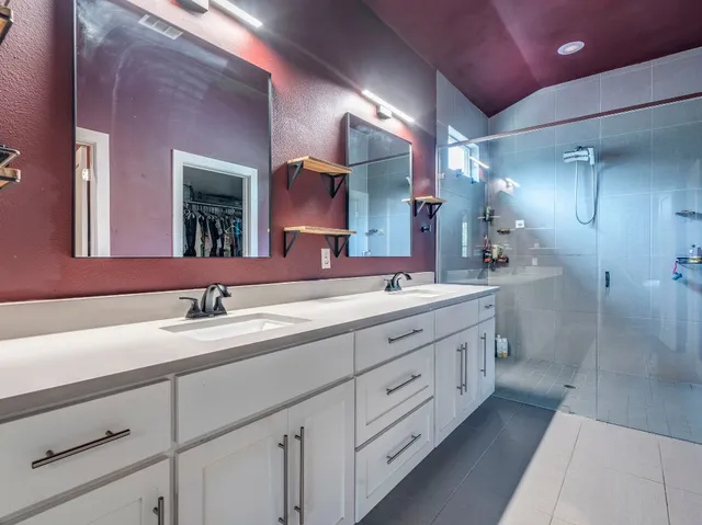 a bathroom with double sink and a mirror