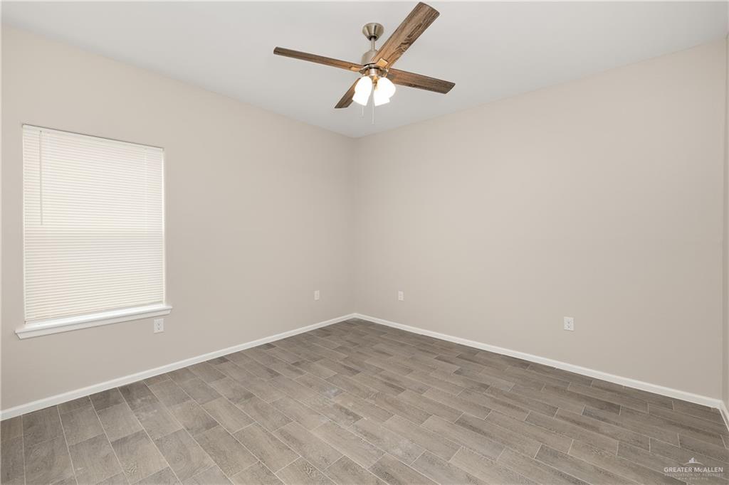 2808 West Harrison Avenue, Unit 4 Alton, TX 78573 - Photo 18 of 22 an empty room with a window and a fan