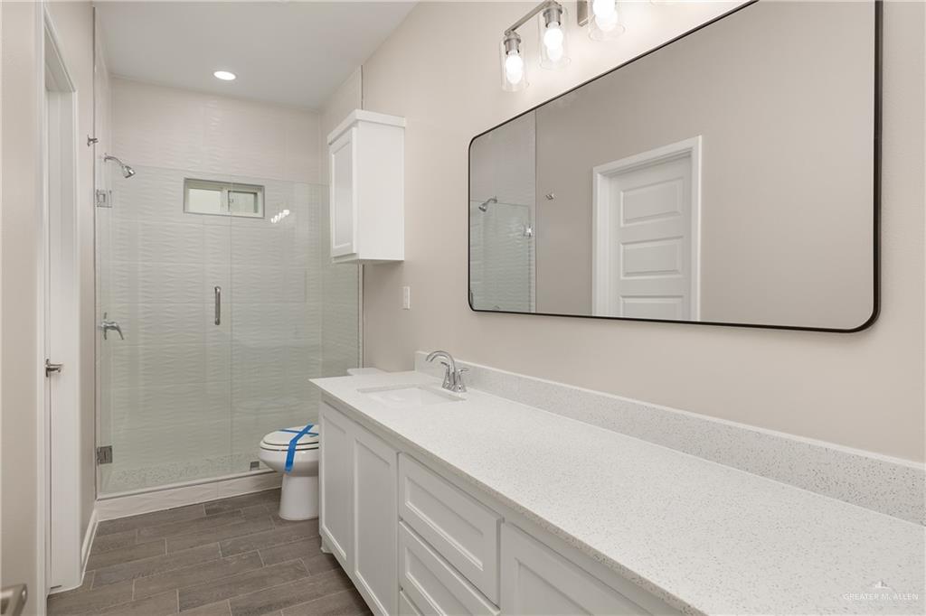 2808 West Harrison Avenue, Unit 4 Alton, TX 78573 - Photo 19 of 22 a bathroom with a sink a toilet and shower