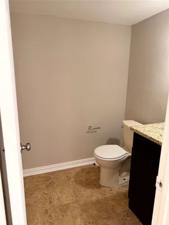 a white toilet sitting next to a white sink and vanity