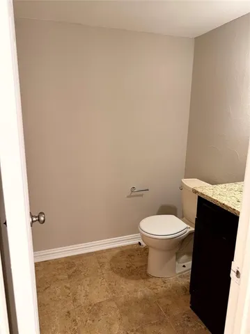 a white toilet sitting next to a white sink and vanity