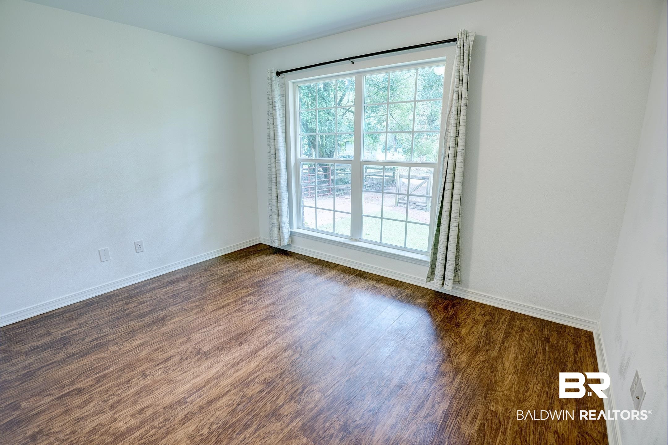 6304 Henshaw Road Fairhope, AL 36532 - Photo 11 of 35 Spare room with dark wood-type flooring and baseboards