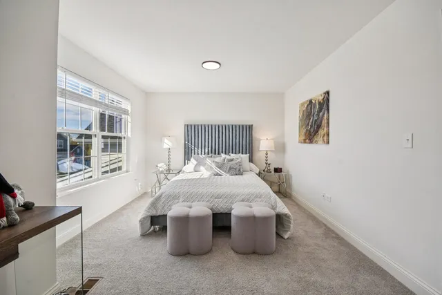 a bed sitting in a bedroom next to a window