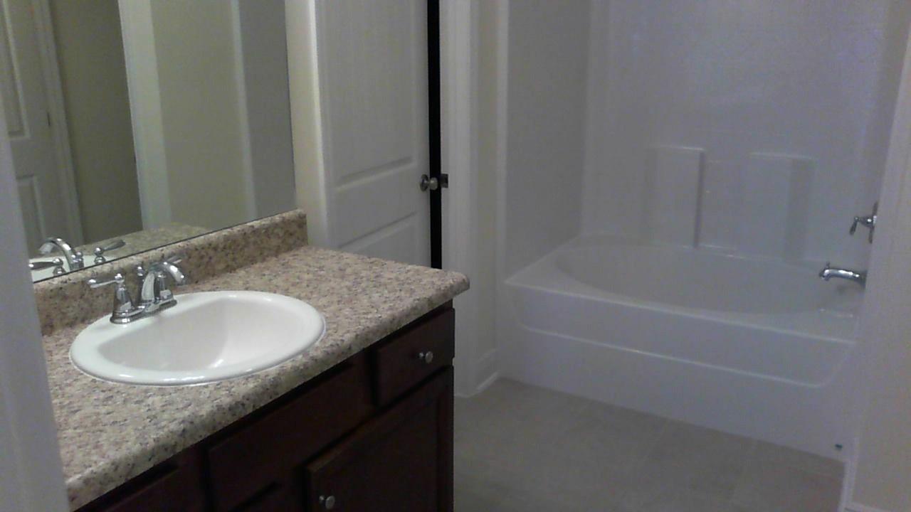 46 Nelly Street Freeport, FL 32439 - Photo 12 of 21 a bathroom with a granite countertop sink a mirror and a bathtub