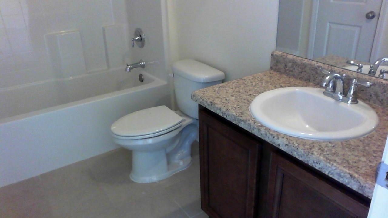 46 Nelly Street Freeport, FL 32439 - Photo 8 of 21 a bathroom with a granite countertop sink and a toilet