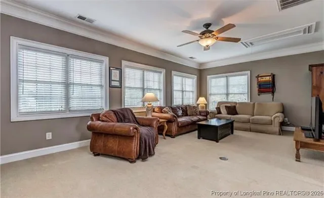 a living room with furniture ceiling fan and a window