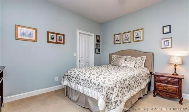 a bedroom with a bed and a lamp on dresser