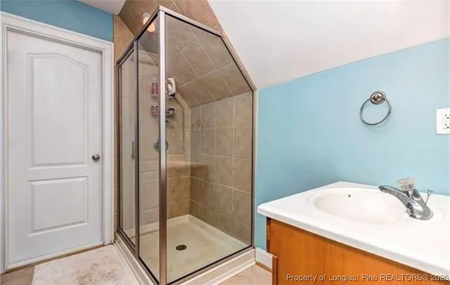 a bathroom with a sink a mirror and a glass door shower