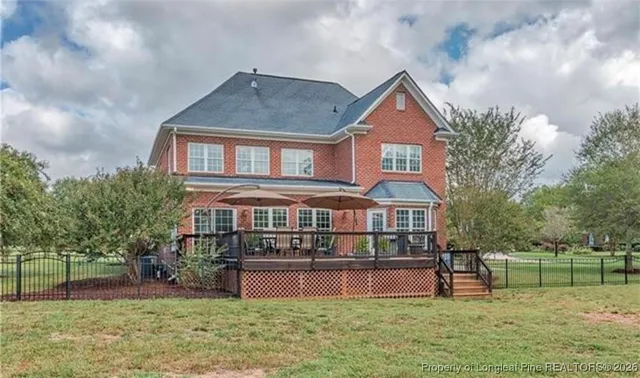 a front view of house with yard and trees in the background