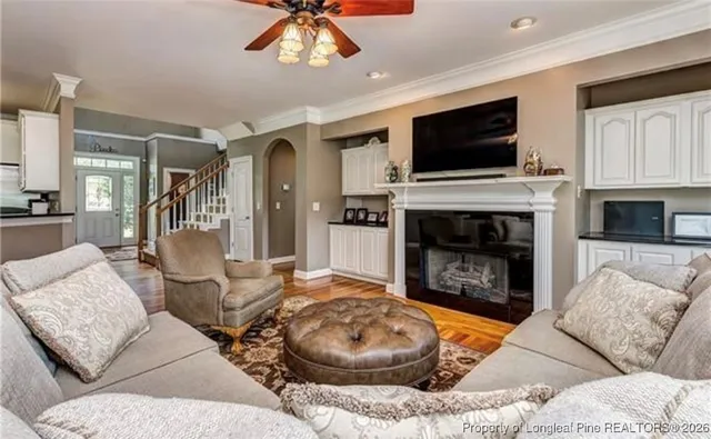 a living room with furniture a flat screen tv and a fireplace