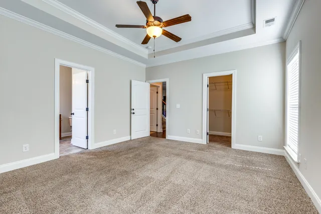 an empty room with closet and a ceiling fan