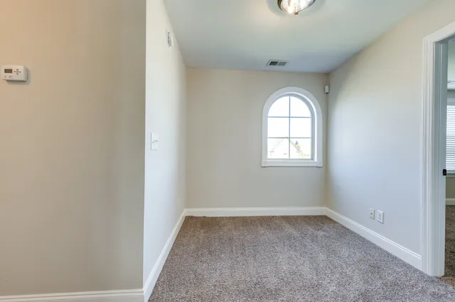 an empty room with a window and mirror