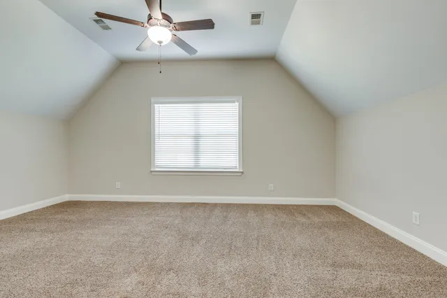 an empty room with a window and ceiling fan