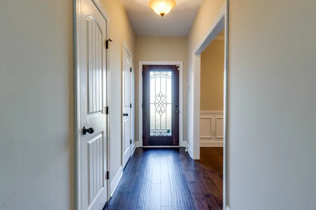 a view of a hallway with wooden floor and closet