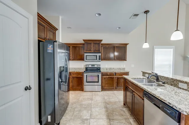 a kitchen with stainless steel appliances granite countertop a sink stove and refrigerator