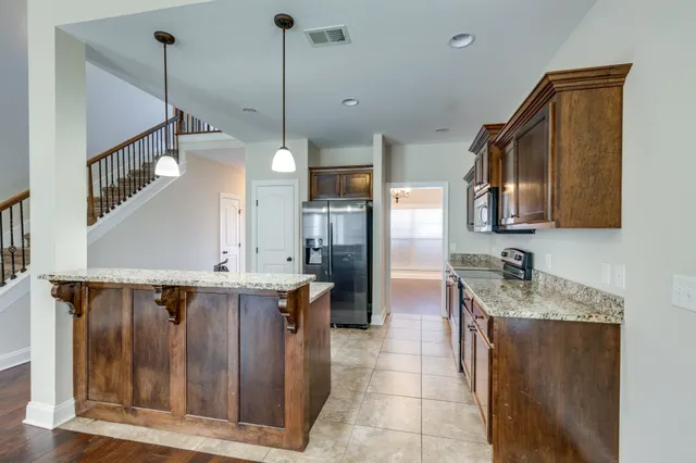 a kitchen with a sink a counter top space appliances and cabinets