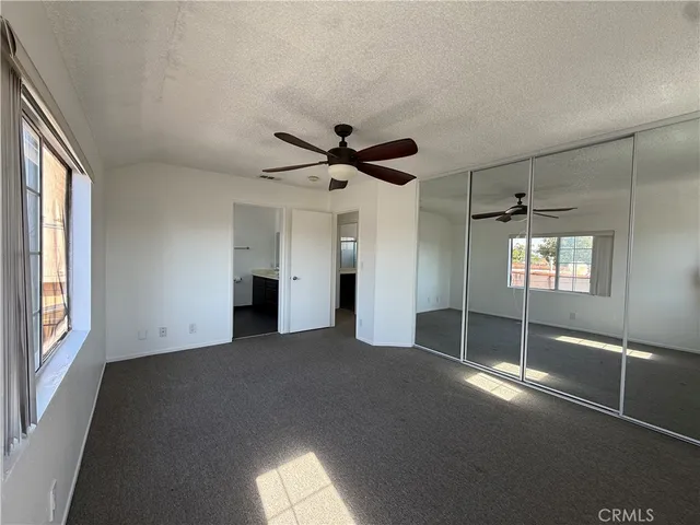 an empty room with windows and closet