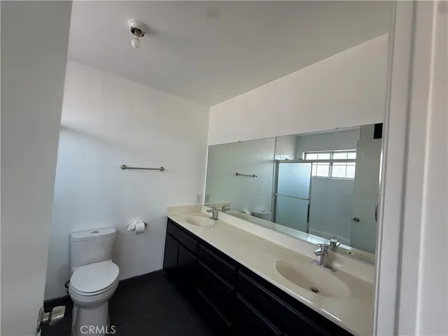 a bathroom with a granite countertop toilet a sink and shower