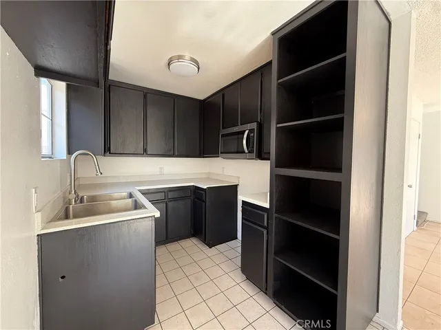 a kitchen with granite countertop a stove sink and microwave