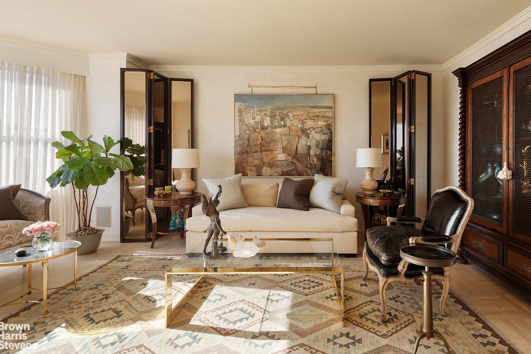 300 East 74th Street, Unit 30AB Manhattan, NY 10021 - Photo 1 of 17 a living room with furniture and a potted plant