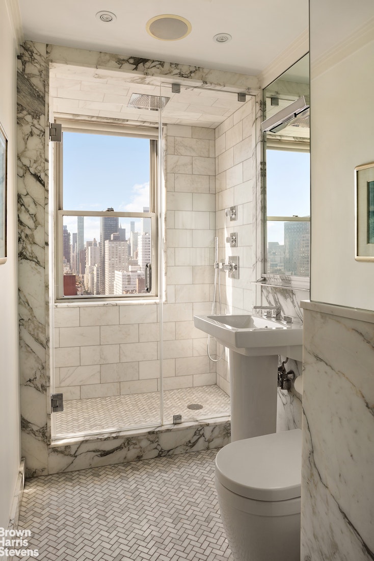 300 East 74th Street, Unit 30AB Manhattan, NY 10021 - Photo 9 of 17 a bathroom with a granite countertop sink toilet and shower