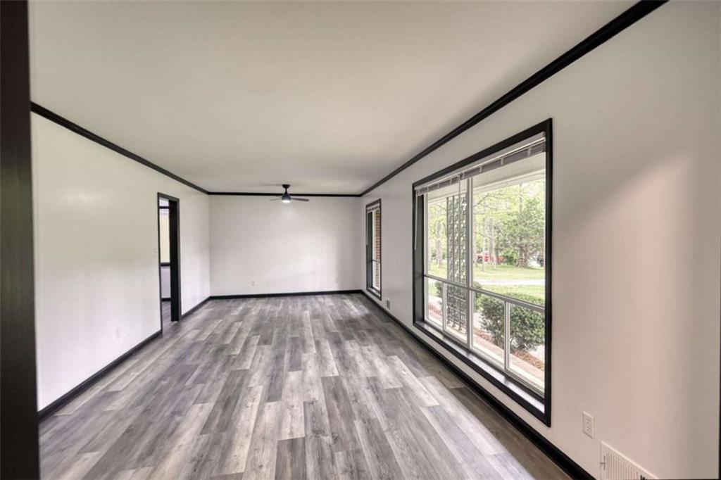 555 Joy Street Jackson, GA 30233 - Photo 8 of 56 a view of empty room with wooden floor and fan