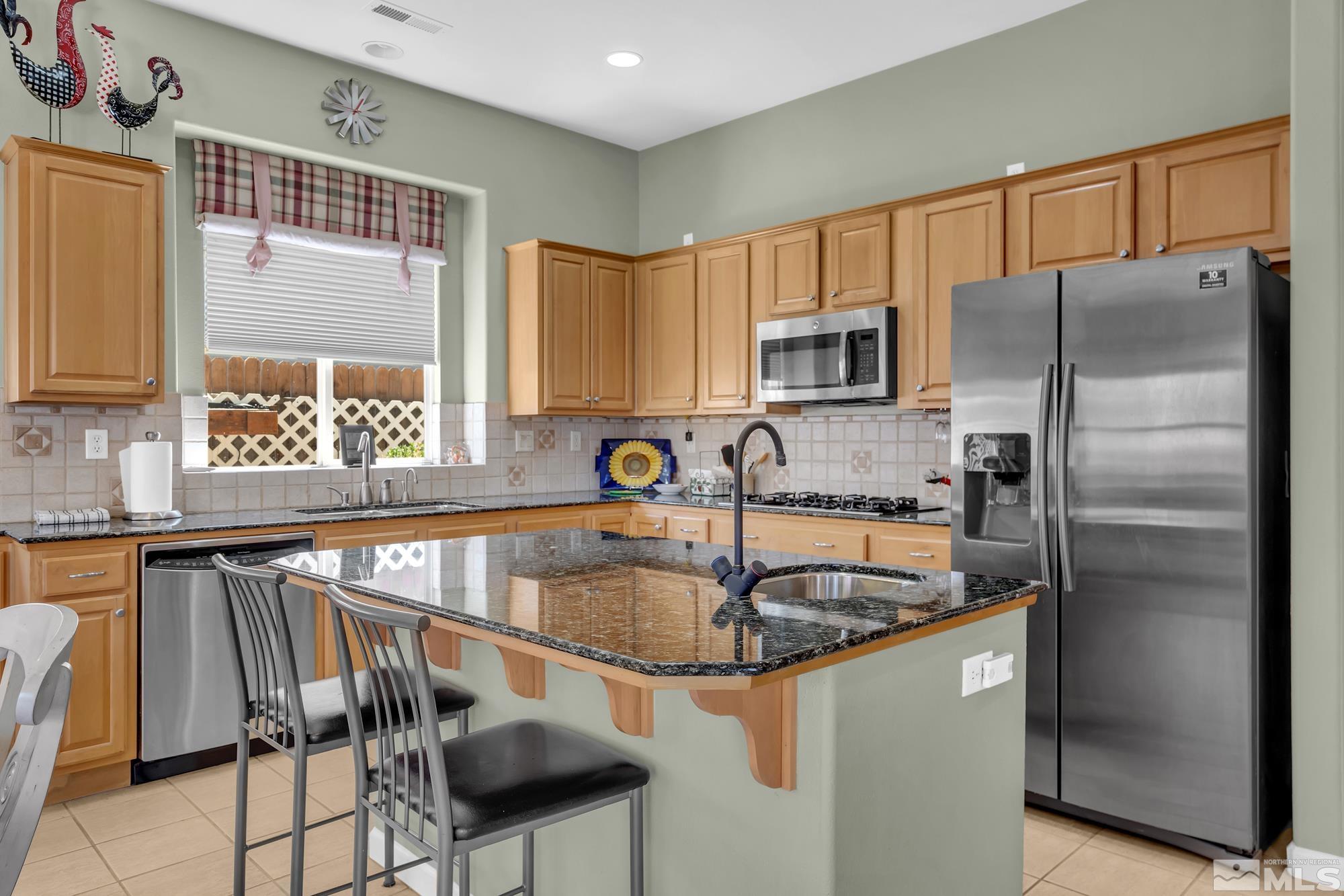 9638 Shadowstone Way Reno, NV 89521 - Photo 17 of 40 a kitchen with a refrigerator a sink and cabinets