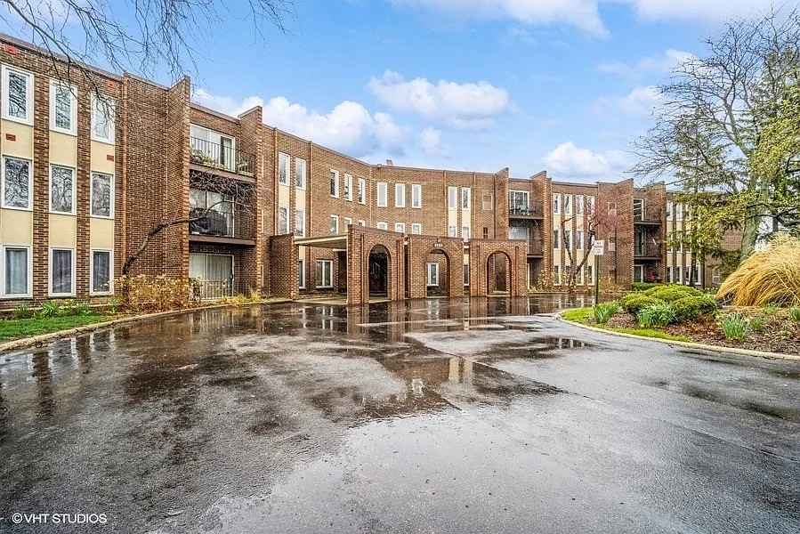 1450 Sandpebble Drive, Unit 227 Wheeling, IL 60090 - Photo 1 of 11 a view of a water with a barbeque and wooden fence
