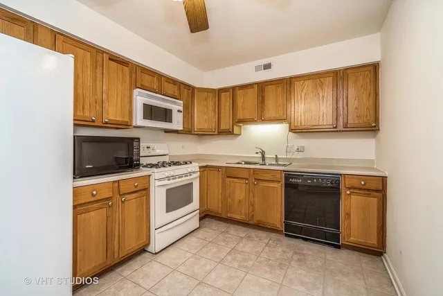 a kitchen with granite countertop a stove top oven microwave and cabinets