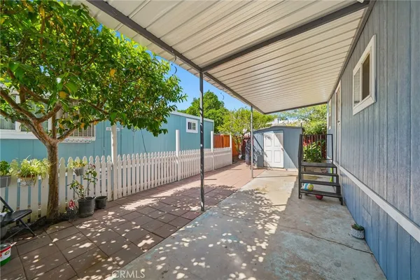 a view of a patio with table and chairs and a large tree