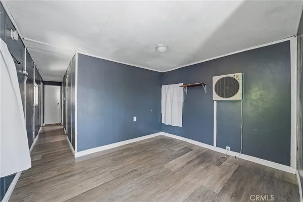 a view of livingroom with an empty space and wooden floor