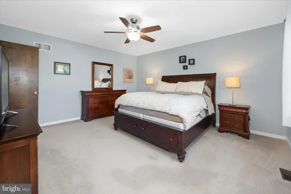 a spacious bedroom with a bed and a ceiling fan
