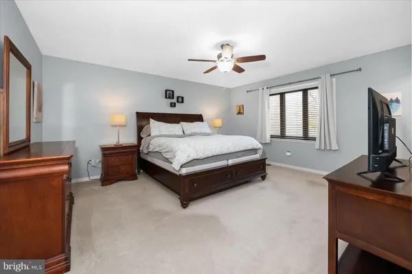 a spacious bedroom with a bed and a flat screen tv