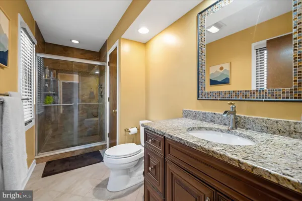 a bathroom with a granite countertop sink toilet and shower