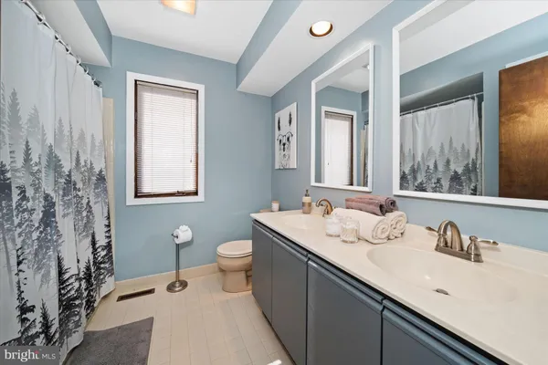 a bathroom with a granite countertop sink mirror and a toilet