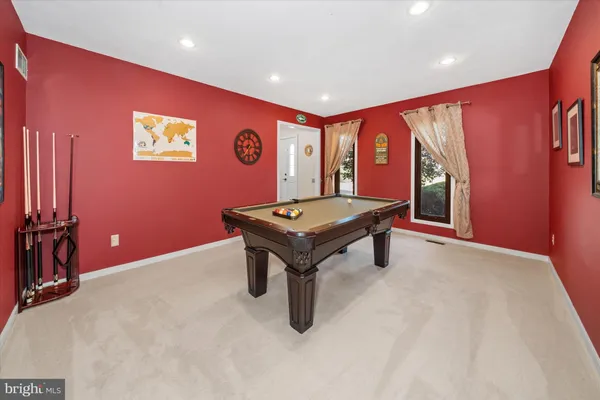 a room with pool table and windows