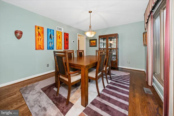 a dining room with furniture a chandelier and wooden floor