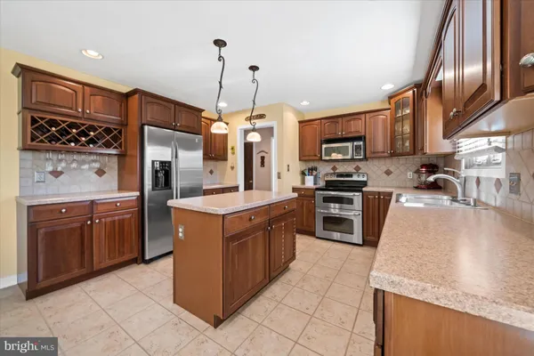 a large kitchen with stainless steel appliances granite countertop a stove oven and a refrigerator