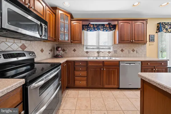 a kitchen with stainless steel appliances granite countertop a stove microwave and cabinets