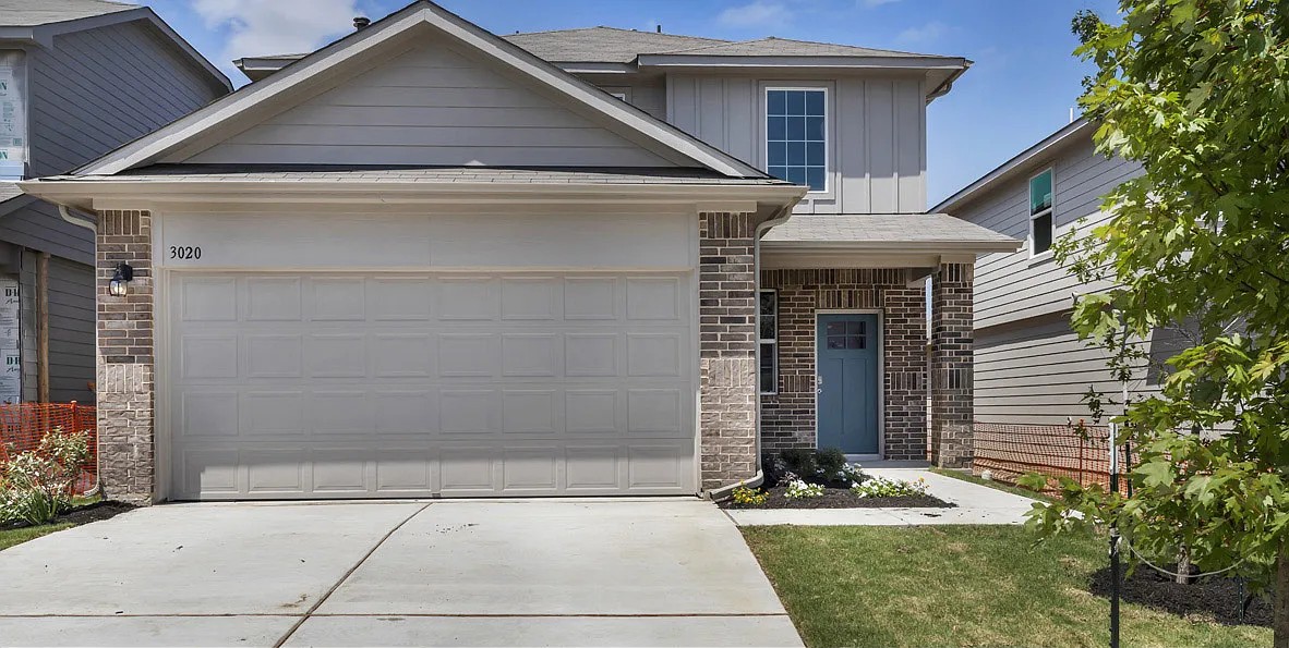 11524 Rush Lane Elgin, TX 78621 - Photo 2 of 29 View of front of property featuring a garage, brick siding, driveway, board and batten siding, and a front yard