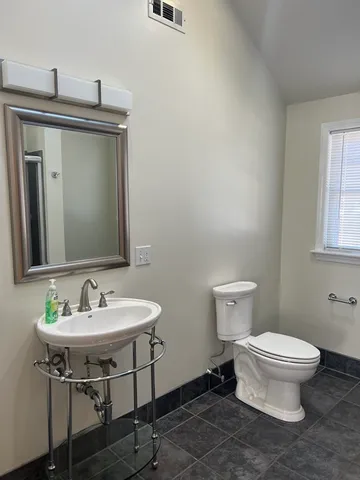 a bathroom with a sink toilet and mirror
