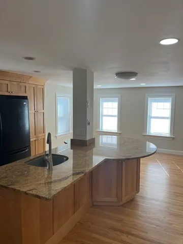 a kitchen with stainless steel appliances granite countertop a sink dishwasher and microwave with wooden floor