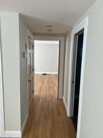 a view of a hallway with wooden floor