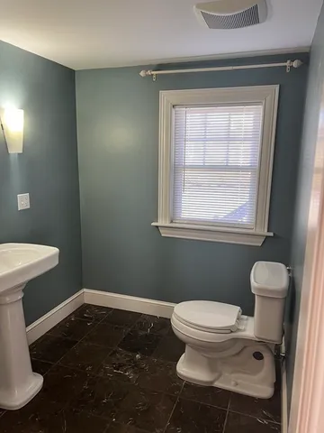 a bathroom with a toilet a sink and a window
